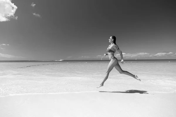 海のビーチで実行されているセクシーな水着の女性 — ストック写真
