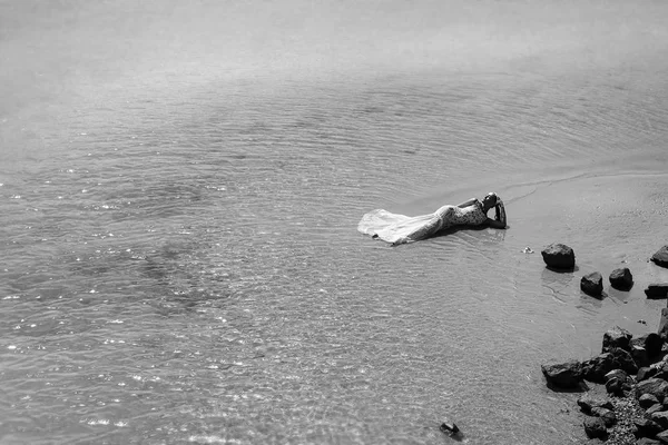 Bride or woman in wedding dress laying on sea beach — Stock Photo, Image