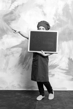 Küçük kız yemek blackboard ile şapkalı.