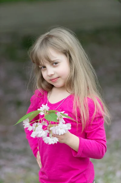 Adorável menina no jardim florescendo cereja — Fotografia de Stock