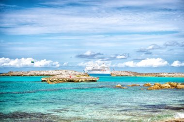 Cruise gemi denizde büyük üzengi cay, Bahamalar güneşli. Okyanus gemisi mavi gökyüzü üzerinde turkuaz su. Karayip yaz tatili. Yolculuk tutkusu, seyahat, gezi. Macera, keşif, yolculuk