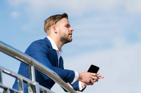 Hombre de negocios con teléfono inteligente en la terraza en el cielo azul, comunicación de negocios — Foto de Stock