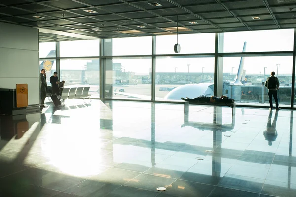 Frankfurt am Main, Saksa - 11. lokakuuta 2015: ihmiset odottavat lentoa lentokentällä isossa ikkunalasissa. Turistimatkustajat matkalaukku, matkatavarat aulassa. Vaeltaminen, loma, matkustaminen — kuvapankkivalokuva