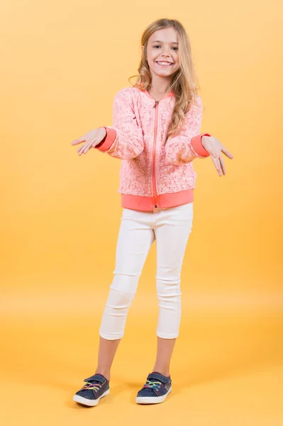 Kleines Mädchen lächelt in Sweatshirt, Hose, Turnschuhen, Mode — Stockfoto