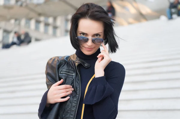 Mujer sensual en gafas de sol en las escaleras en París, Francia, belleza. Mujer con el pelo morena en ropa negra, de moda. Ambición, desafío, éxito. Moda, accesorio, estilo. Belleza, look, peinado — Foto de Stock