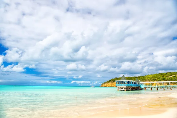 加勒比的暑假。在安提瓜有木制庇护所的海滨海滩。码头在蓝绿色的水在多云的天空背景。流浪, 旅行, 旅行。探险, 发现, 旅程. — 图库照片