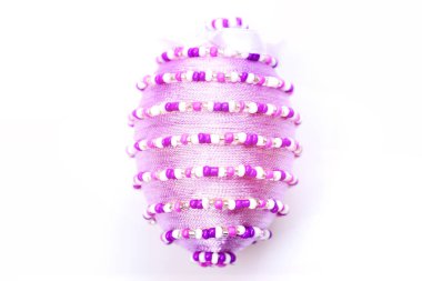 İplik ve beyaz boncuklarla süslenmiş yumurta.