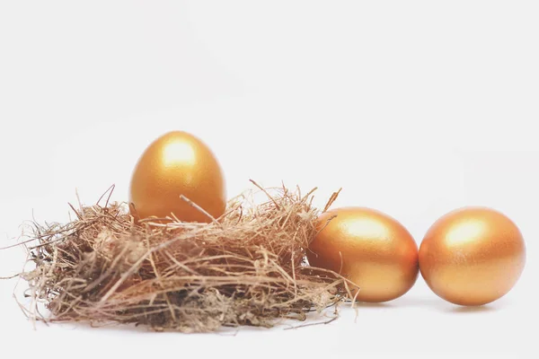 Huevos tradicionales pintados en color dorado dentro del nido —  Fotos de Stock