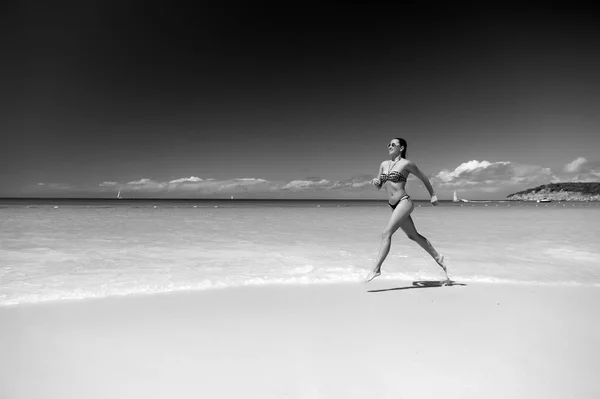 Donna in bikini in esecuzione sulla spiaggia di mare — Foto Stock