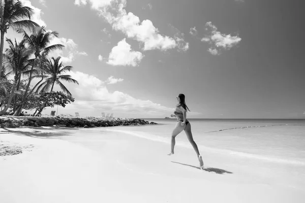 Giovane donna che corre sulla spiaggia tropicale — Foto Stock