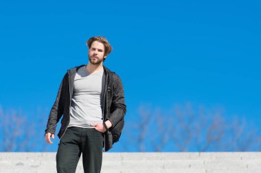 Mavi gökyüzünde maço duruşu, perspektif. Güneşli açık havada sakallı bir adam, moda. Bakış açısı, gelecek, özgürlük. Erkek modası ve tarzı, kopyalama alanı