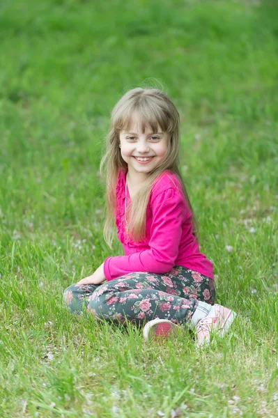 Kid úsměv na zelené trávě, jaro — Stock fotografie