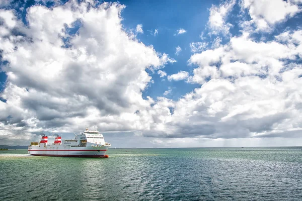 Statek w morze na zachmurzone niebo niebieski. Seascape ocean liner i chmury. Letnie wakacje, przygoda i wanderlust koncepcja. Transport wodny, transport, Podróże — Zdjęcie stockowe