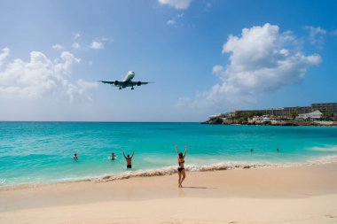 Philipsburg, sint maarten sahilde insanlar üzerinde uçak arazi. Jet mavi deniz üzerinde düşük uçmak uçuş. Uçağın içinde bulutlu mavi gökyüzü. Caribbean Beach Tatil. Yolculuk tutkusu, seyahat ve gezi