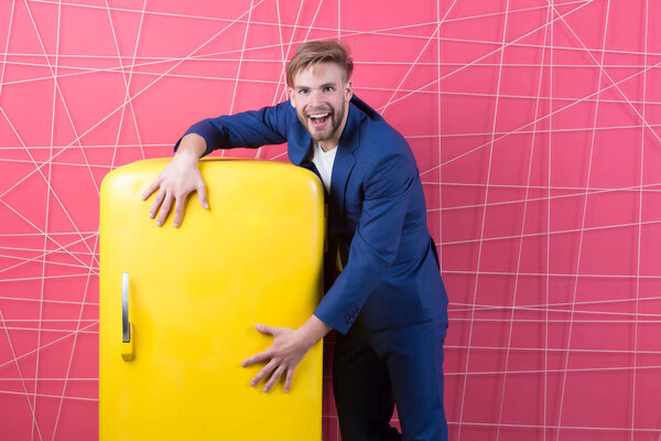 Счастливчик держит ретро-холодильник. Мачо улыбается с холодильником. Бизнесмен в официальном костюме. Кухонная мебель и бытовая техника. Продажа онлайн и концепция киберпонедельника
