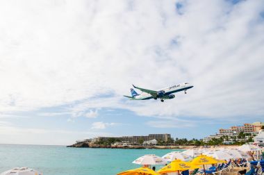 Philipsburg, Sint Maarten - 24 Ocak 2016: jet düşük uçmak uçuş maho plaj üzerinde. Bulutlu gökyüzü uçak karada. Uçak kişi mavi denizde. Yolculuk tutkusu, seyahat ve gezi. Caribbean Beach Tatil