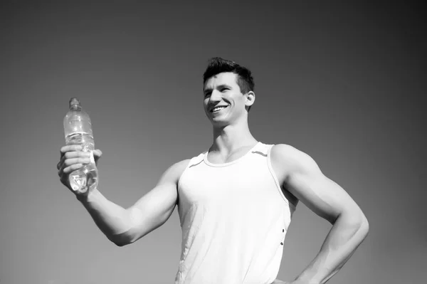 Uomo felice con bottiglia d'acqua in mani muscolose — Foto Stock