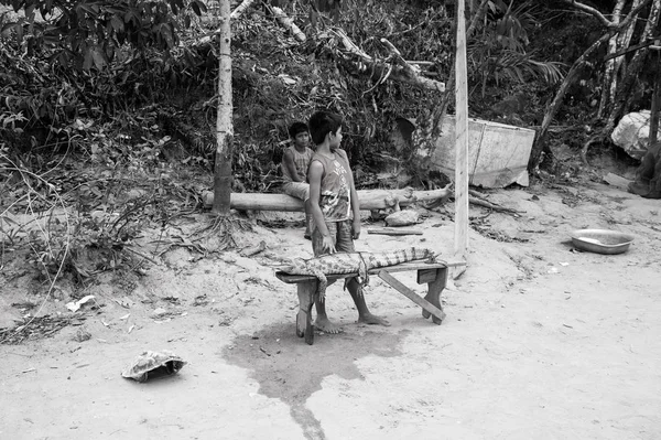 Garçons vendant du crocodile lié à un banc en bois — Photo