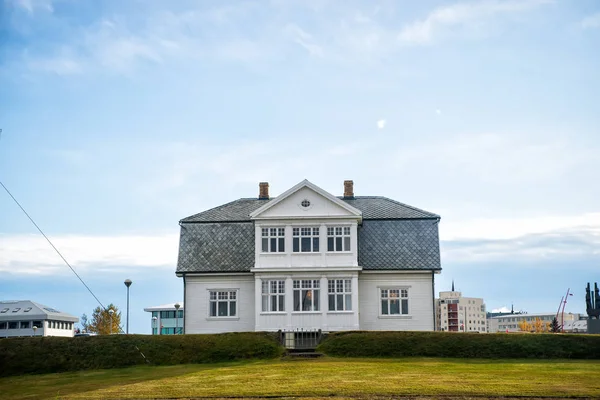 House with green lawn on blue sky in reykjavik, iceland. Architecture, structure and design. Village or small town building, real estate — Stock Photo, Image