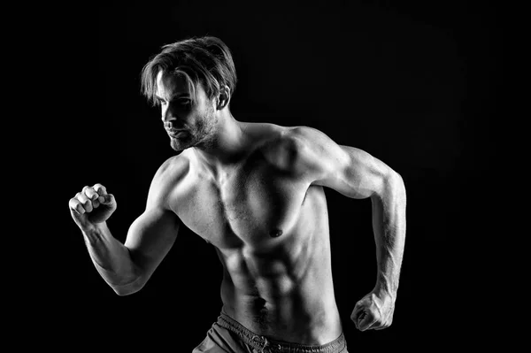 Sportsman in running position, sport. Sexy macho with fit bare torso, fitness. Bearded man with six pack and ab muscles, sport. Athlete training with energy and power, black and white — Stock Photo, Image