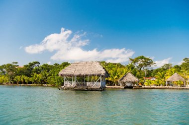 Kulübe Guatemala, santo tomas deniz kıyısında. Evlerin ahşap ve tropikal mavi gökyüzü güneşli kumsalda çimlere. Adada tatil yaz. Yolculuk tutkusu, macera ve keşif