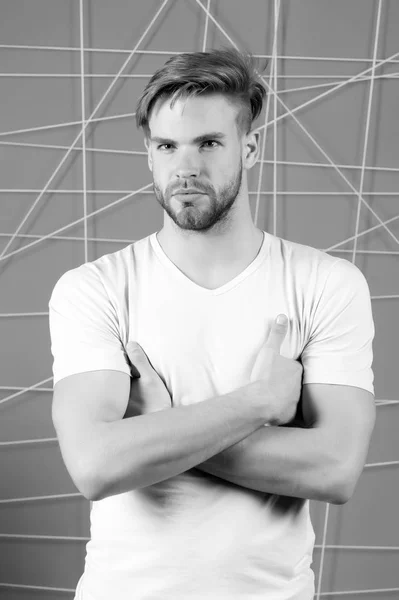 Macho con cabello rubio, corte de pelo elegante. Cuidado del cabello en peluquería o peluquería. Hombre de camiseta con las manos dobladas. Tipo con la cara barbuda sin afeitar. Belleza y aseo para hombre, blanco y negro —  Fotos de Stock