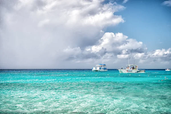 Grand Turk, Islas Turcas y Caicos - 29 de diciembre de 2015: barcos de motor en mar turquesa en el cielo nublado. Barcos en idílico paisaje marino. Aventura acuática y viajes. Vacaciones de verano en isla tropical — Foto de Stock