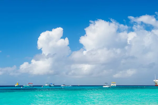 Barcos em mar azul-turquesa ou oceano em grandes ilhas turcas, turcas e caicos. Seascape com água limpa no céu nublado. Descoberta, aventura e luxúria. Férias de verão na ilha tropical — Fotografia de Stock