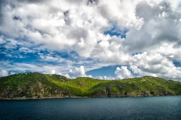 Ορεινή ακτή στο γαλάζιο της θάλασσας στο συννεφιασμένο ουρανό σε Γουσταβία, st.barts. Καλοκαιρινές διακοπές σε τροπικό νησί. Άγρια φύση και περιβάλλον, οικολογία. Προορισμός για διακοπές και τα ταξίδια στο όμορφο τοπίο. — Φωτογραφία Αρχείου