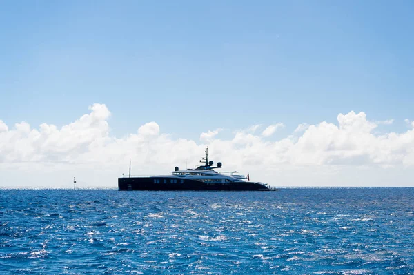 Nave o yate en el mar en el cielo azul en gustavia, st.barts. Viajes de lujo en barco y aventura. Transporte de buques y agua. Vacaciones de verano y destino de vacaciones — Foto de Stock