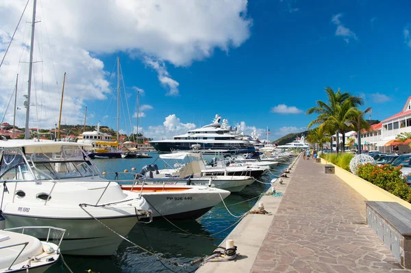 Γουσταβία, st.barts - 25 Ιανουαρίου 2016: βάρκες και σκάφη αγκυροβολημένα στη θάλασσα προβλήτα σε τροπική παραλία. Ιστιοπλοΐα και ιστιοπλοΐα. Πολυτελή ταξίδια με βάρκα. Καλοκαιρινές διακοπές στο νησί. Θαλάσσια συγκοινωνία και σκάφος — Φωτογραφία Αρχείου