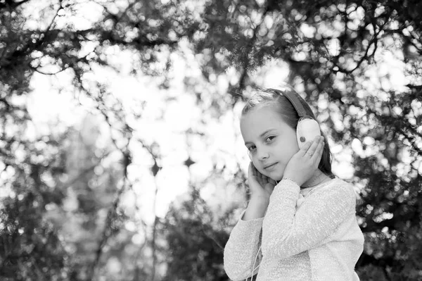 Bonita niña disfrutando de la música usando auriculares — Foto de Stock