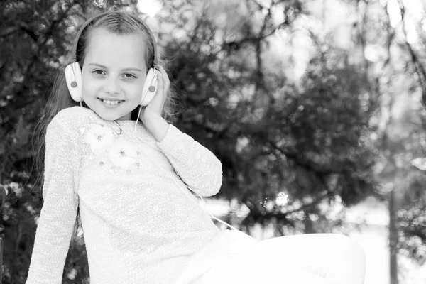 Csinos kislány élvezi a zenét fülhallgatóval — Stock Fotó