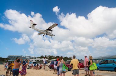 Philipsburg, Sint Maarten - 13 Şubat 2016: Yolculuk tutkusu, seyahat ve gezi. Uçak arazi maho plaj üzerinde. Jet Uçuş bulutlu mavi gökyüzü düşük anında. Uçağın içinde güneşli bulutlar. Caribbean Beach Tatil