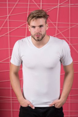 Fotokopi alanı olan beyaz tişörtlü adam pembe duvar arkasında duruyor.