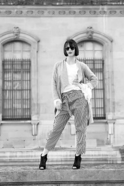 Yüksek topuklu ayakkabılı, şık elbiseli bir model.