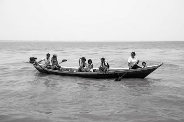 İnsanlar kahverengi su yüzeyi teknede kürek
