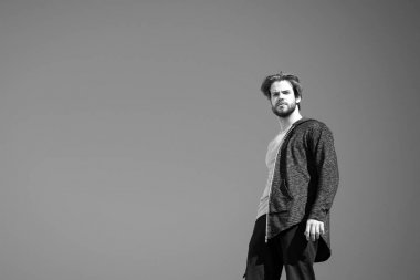 Gri ceketli adam mavi gökyüzünde duruyor.