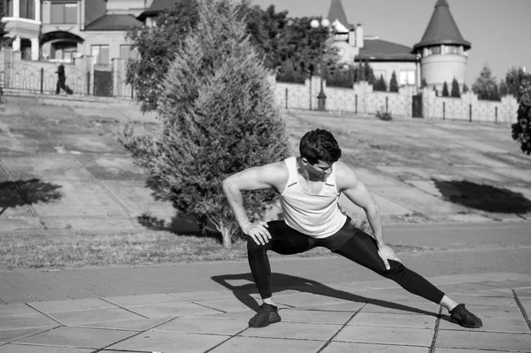 Ajuste macho en traje de atletismo en paisaje urbano — Foto de Stock