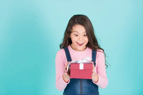 Sonrisa de niña pequeña con caja de regalo, lazo de cinta — Foto de Stock