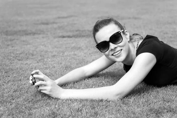 Kobieta uśmiechnięta aparatem fotograficznym na zielonej trawie w Paryżu, Francja — Zdjęcie stockowe
