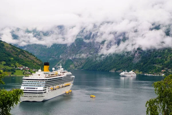 Geiranger, Norway - January 25, 2010: passenger liner docked in port. Cruise ship in norwegian fjord. Travel destination, tourism. Adventure, discovery, journey. Vacation, trip, wanderlust. — Stock Photo, Image