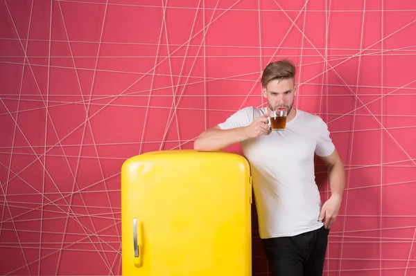 Man hold cup of tea or coffee in kitchen. Macho drink at retro fridge on pink background. Bachelor with morning drink at refrigerator. Breakfast refreshment and energy. Healthy diet for cold or flue — Stock Photo, Image