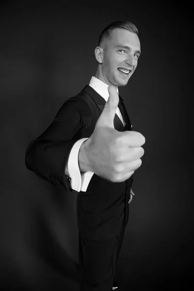 Brudgummen eller affärsman leende med tummen upp handen. Mannen leende med hand gest. Glad tävlingsdansare i snygg smoking. Godkännande och framgång koncept, svart och vitt — Stockfoto