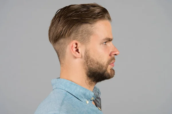 Man with bearded face in profile. Macho with beard and mustache. Guy with stylish hair and unshaven skin. Beard grooming and hair care in barbershop. Skincare and mens beauty concept — Stock Photo, Image