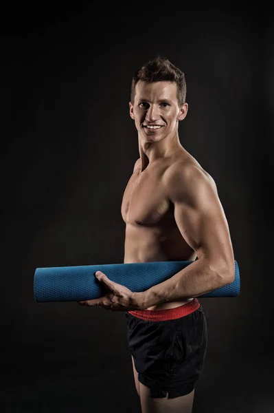 Idrottsman leende med sexig kropp och bröst. Sportsman leende med yogamatta. Lycklig man med muskulösa armar med biceps. Gymutrustning för utbildning och träning. Sport yoga och pilates aktivitet, vintage — Stockfoto