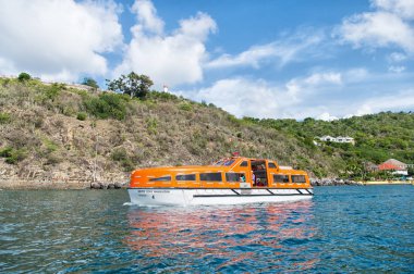 Gustavia, st.barts - 25 Kasım 2015: Gemi deniz kıyısı boyunca mavi deniz seyahat. Su ulaştırma araçları ve gemi. Denizde Yolculuk tutkusu seyahat. Tropik adada tatil yaz