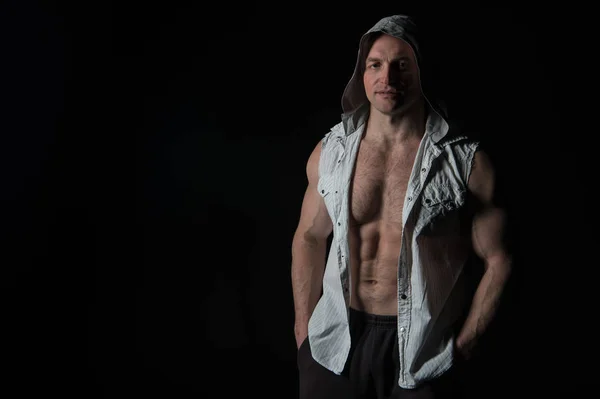 Man atleet slijtage kap. Bodybuilder met fit romp spieren. Sportman Toon biceps en triceps in mouwloos shirt. Sport macht en bodycare concept. Training en opleiding activiteit in sportschool, kopie ruimte — Stockfoto