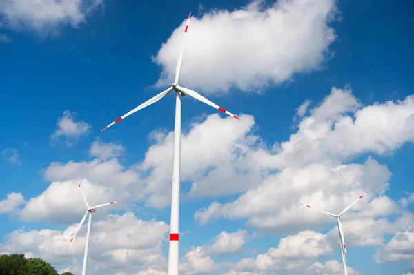 Wind turbine on cloudy blue sky. Alternative energy and electricity source. Global warming. climate change and ecology. Eco power and green technology concept — Stock Photo, Image