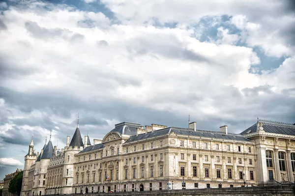 Palais de la Cite στο Παρίσι, Γαλλία. Παλάτι κτίριο με πύργους στο συννεφιασμένο ουρανό. Μνημείο της γοτθικής αρχιτεκτονικής και του σχεδιασμού. Διακοπές και περιπλάνησης στη γαλλική πρωτεύουσα — Φωτογραφία Αρχείου